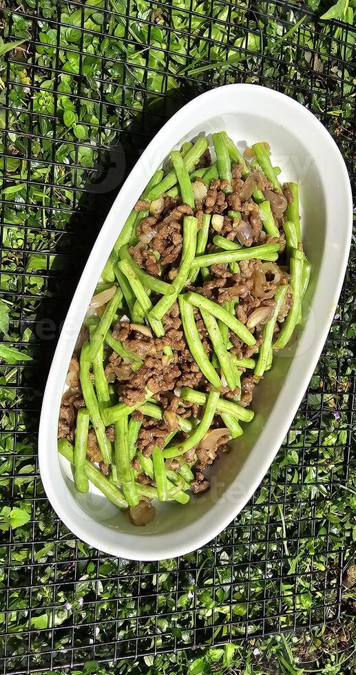 String green bean or french beans with minced beef stir fry or sauteed called Tumis buncis daging sapi cincang in Indonesia photo