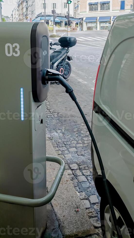 Electric vehicle charging at a public station on a city street, representing sustainable transportation and eco friendly travel concepts photo