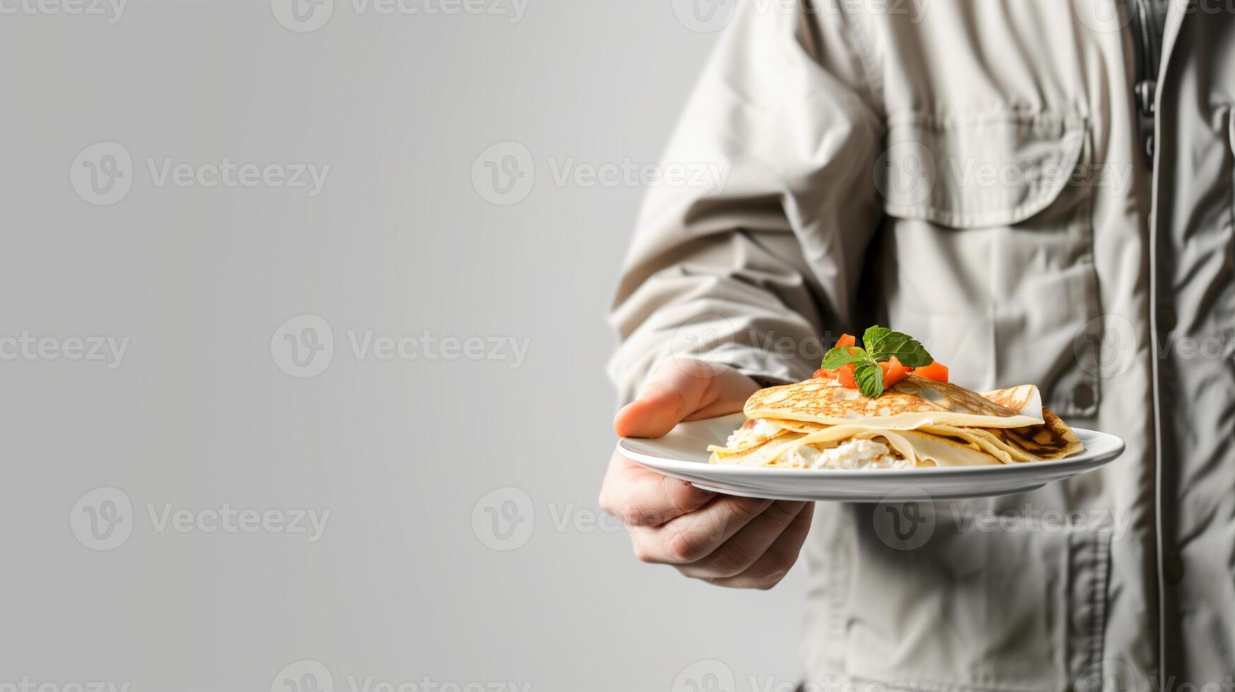 Person presenting a plate of crepes garnished with fruit, ideal for culinary blogs, Shrove Tuesday celebrations, and breakfast concept imagery photo