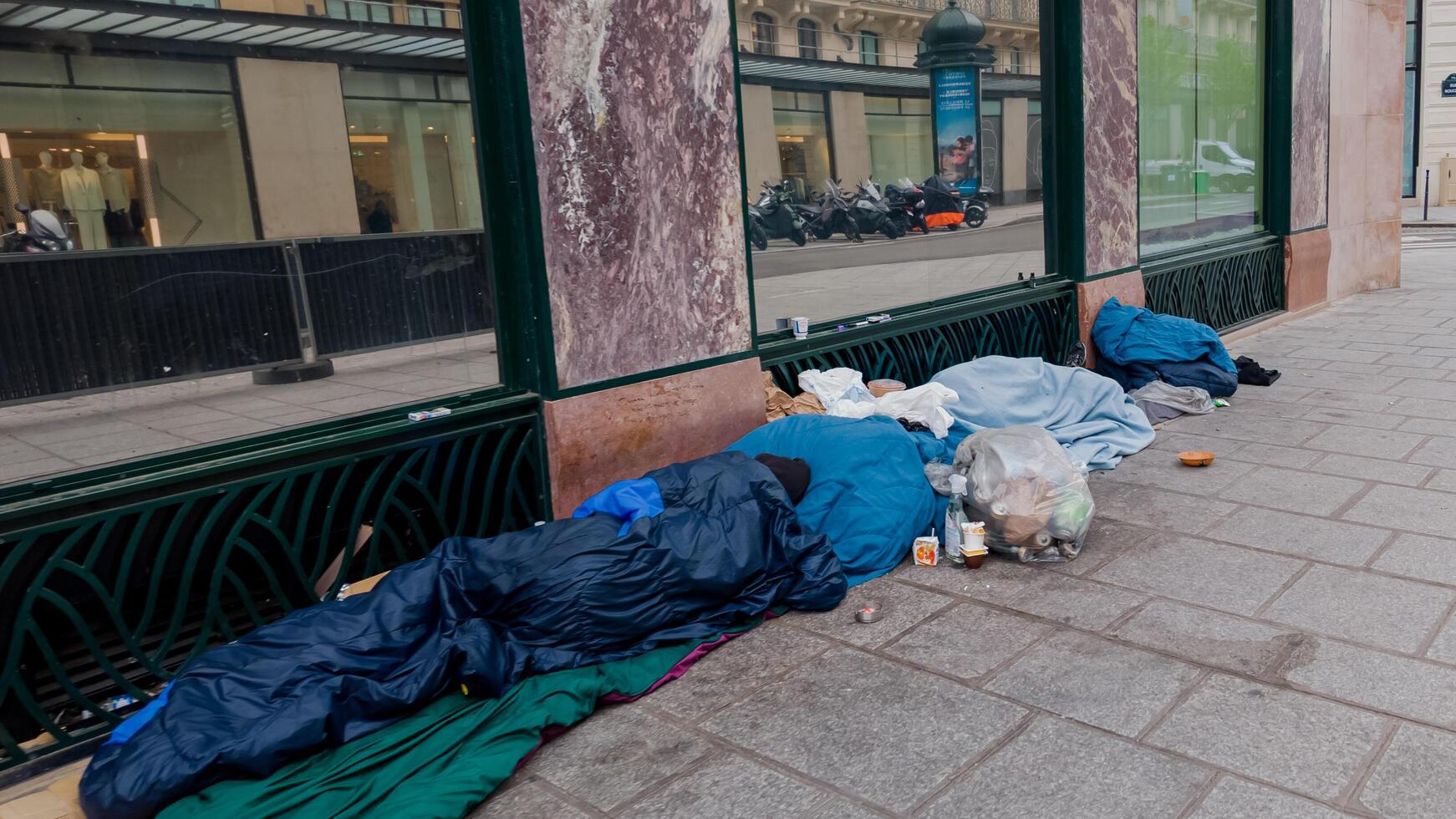 Urban street scene depicting homelessness with sleeping bags on a sidewalk, drawing attention to social issues and World Homelessness Day photo
