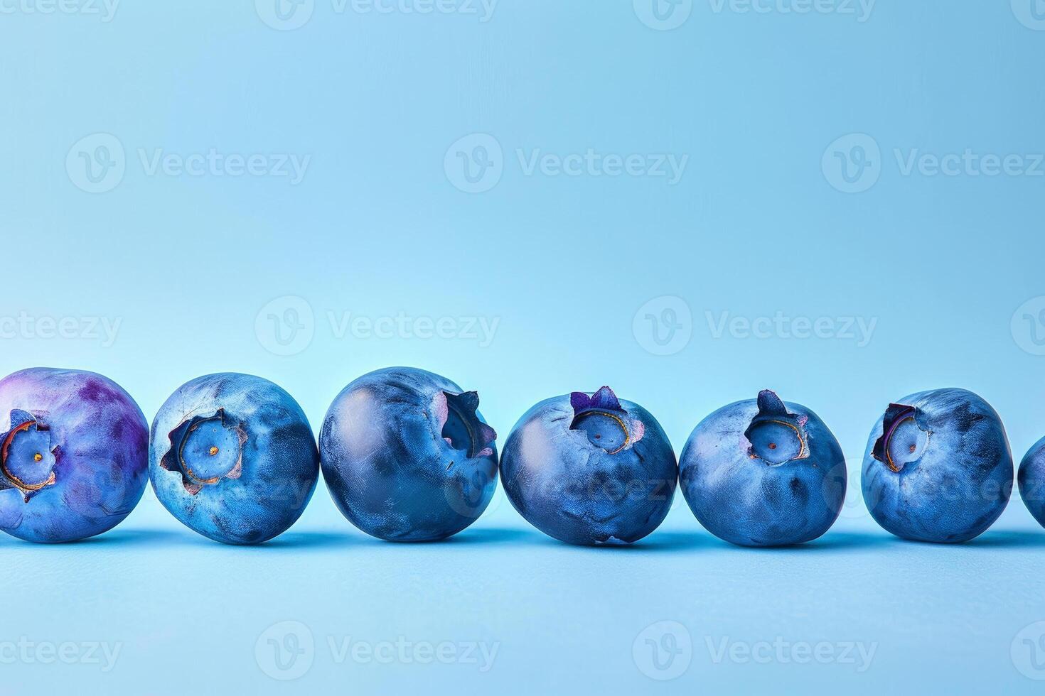 Stylized graphic of multiple blueberries in a descending size order, gradient blue background photo