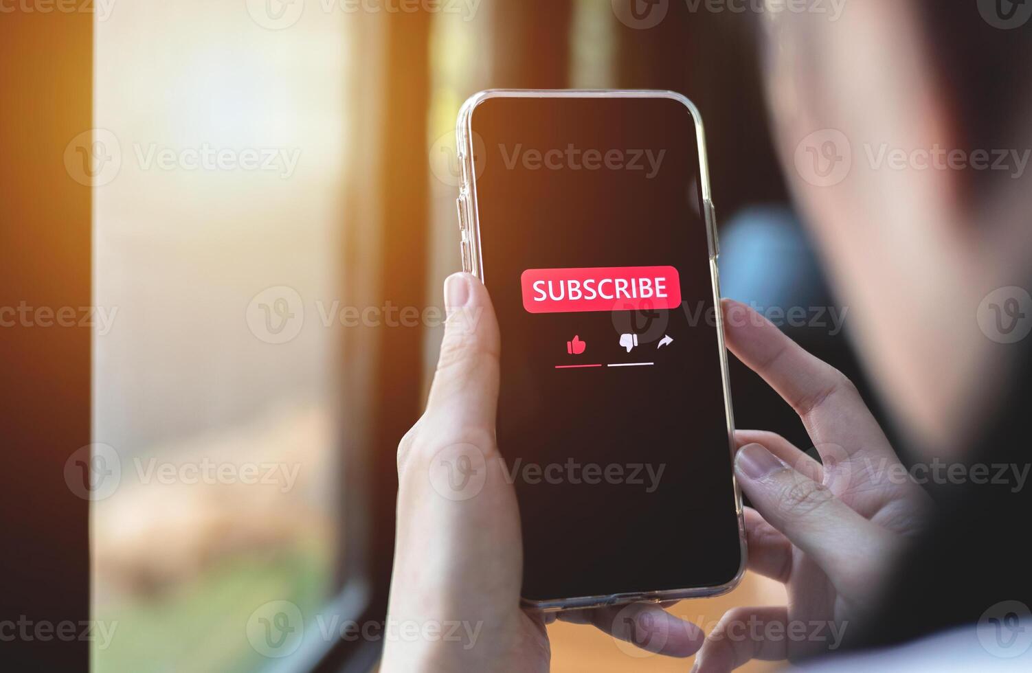 Close-up view of a woman using a smartphone to press red subscribe button on online media. Concepts of technology and following news, hot trends and new content on social media photo