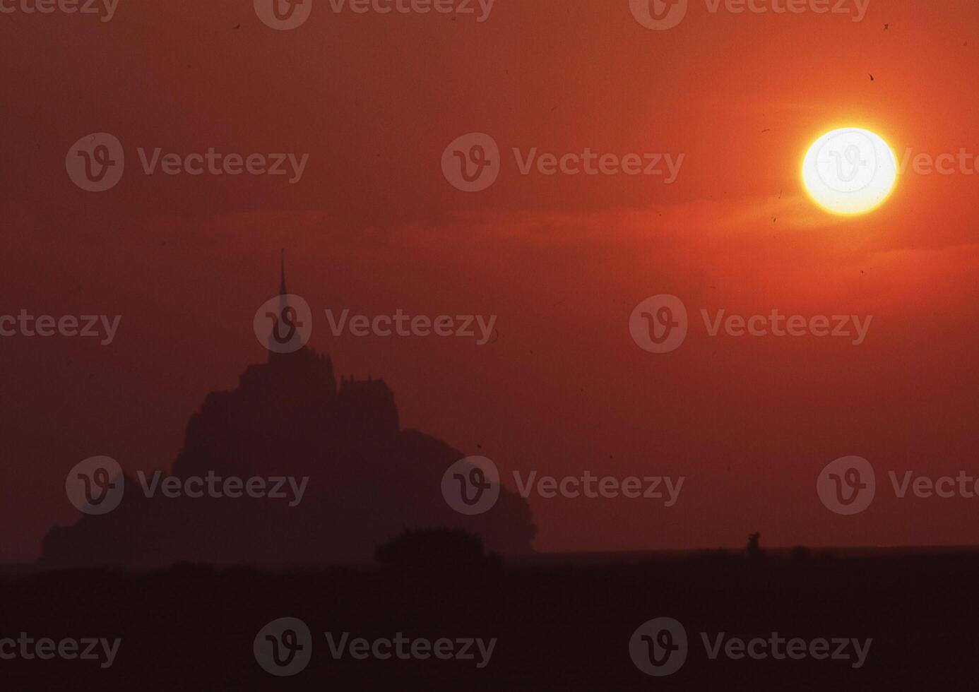 the sun sets behind a mountain in the background photo