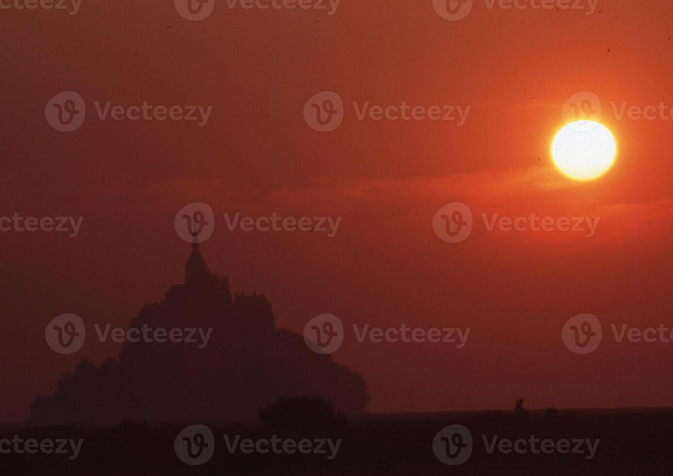 the sun sets behind a mountain in the background photo