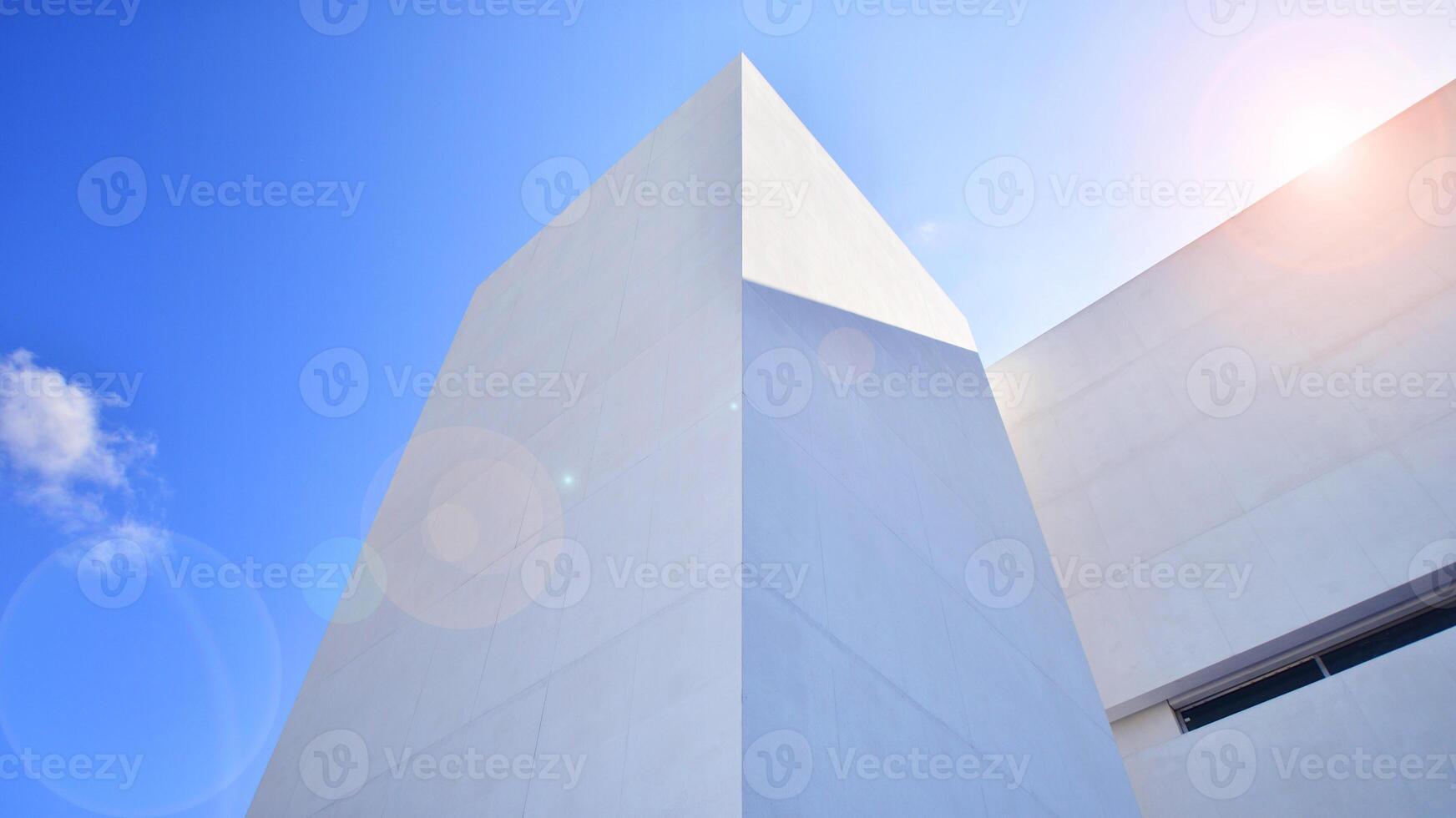 Sunlight and shadow on surface of white Concrete Building wall against blue sky background, Geometric Exterior Architecture in Minimal Street photography style photo