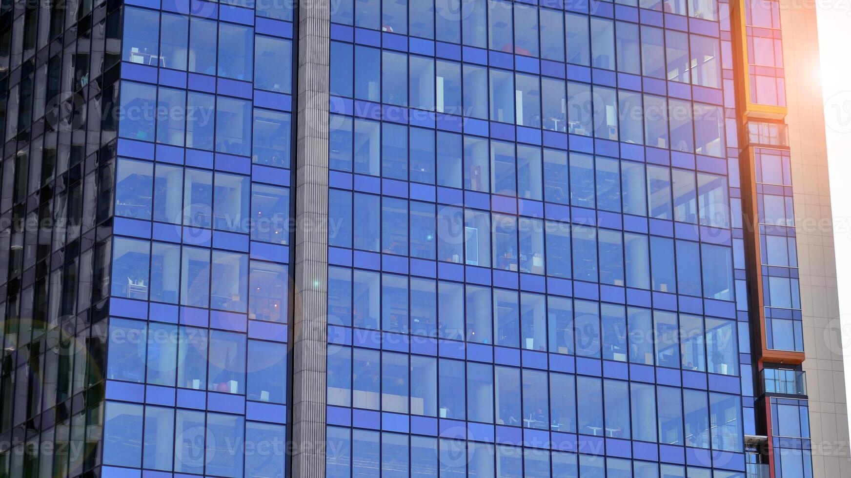 Glass building with transparent facade of the building and blue sky. Structural glass wall reflecting blue sky. Abstract modern architecture fragment. Contemporary architectural background. photo