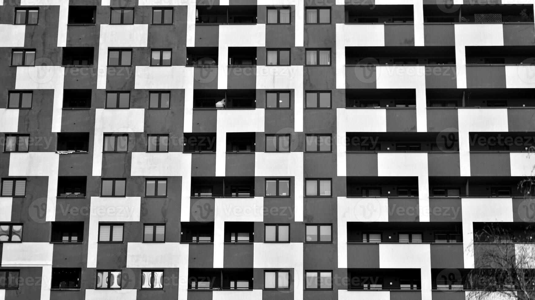Fragment of the building's facade with windows and balconies. Modern apartment buildings on a sunny day. Facade of a modern residential building. Black and white. photo