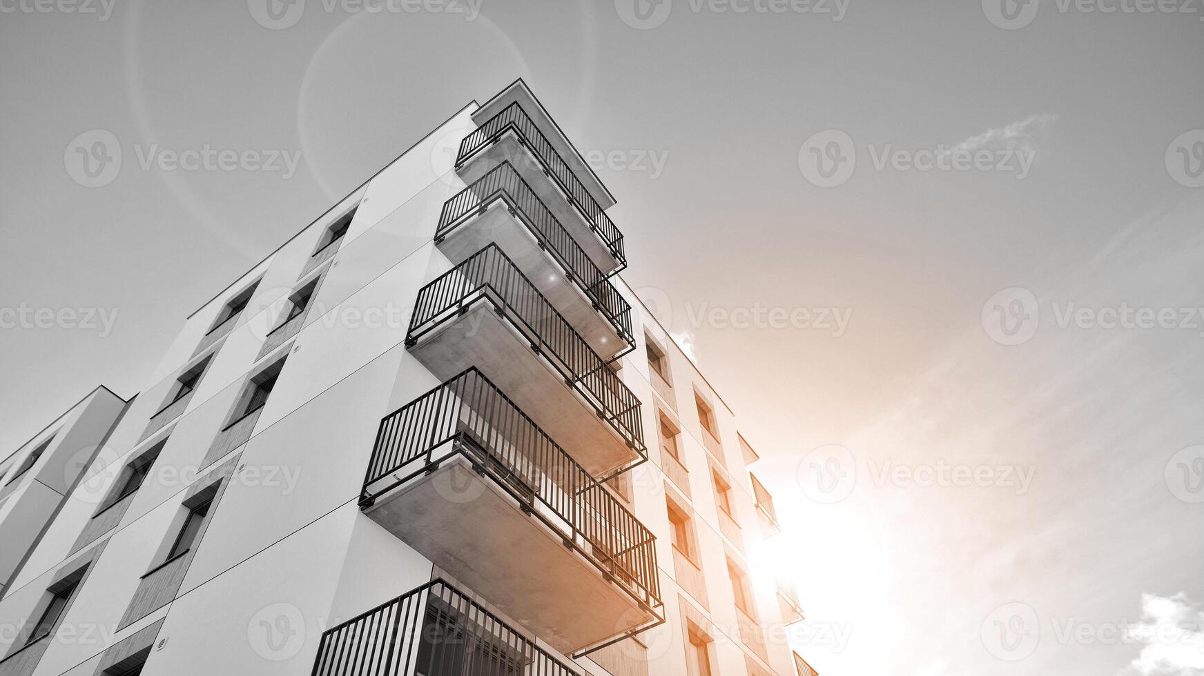Fragment of the building's facade with windows and balconies. Modern apartment buildings on a sunny day. Facade of a modern residential building. Black and white. photo
