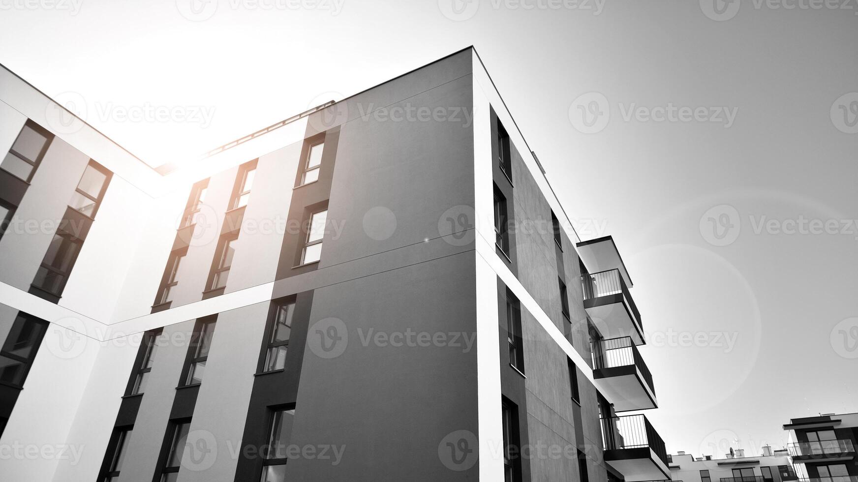 Fragment of the building's facade with windows and balconies. Modern apartment buildings on a sunny day. Facade of a modern residential building. Black and white. photo