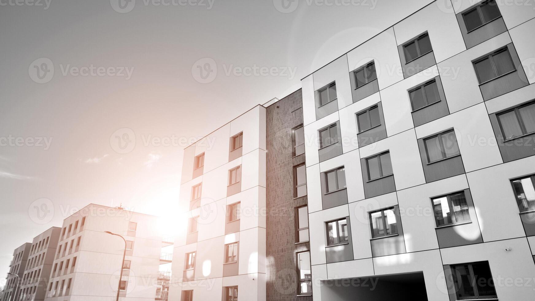 Fragment of the building's facade with windows and balconies. Modern apartment buildings on a sunny day. Facade of a modern residential building. Black and white. photo