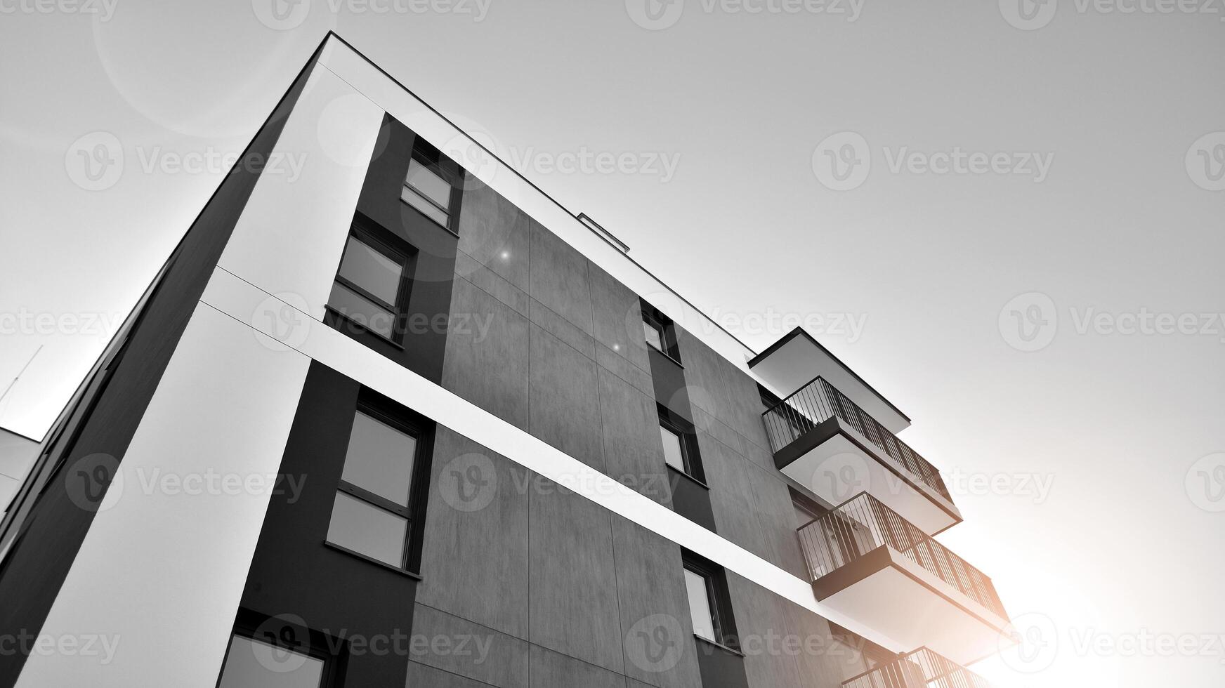 Fragment of the building's facade with windows and balconies. Modern apartment buildings on a sunny day. Facade of a modern residential building. Black and white. photo