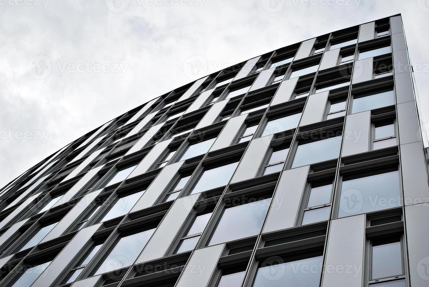 Glass building with transparent facade of the building and blue sky. Structural glass wall reflecting blue sky. Abstract modern architecture fragment. Contemporary architectural background. photo