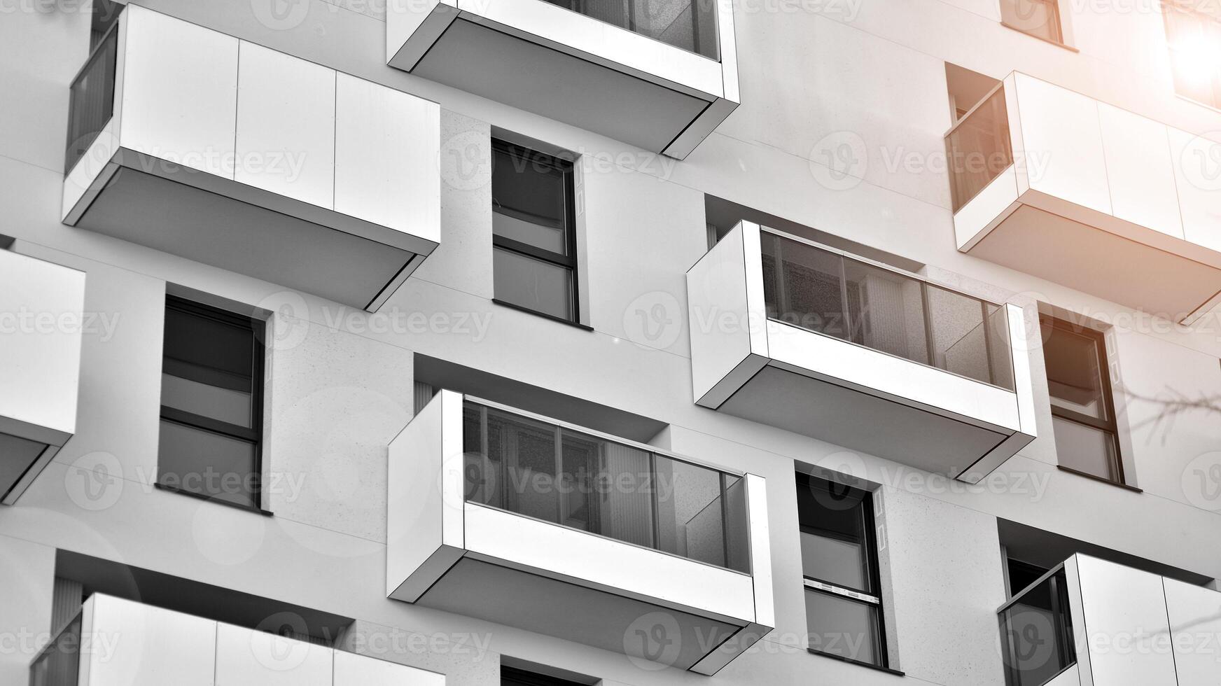 Fragment of the building's facade with windows and balconies. Modern apartment buildings on a sunny day. Facade of a modern residential building. Black and white. photo