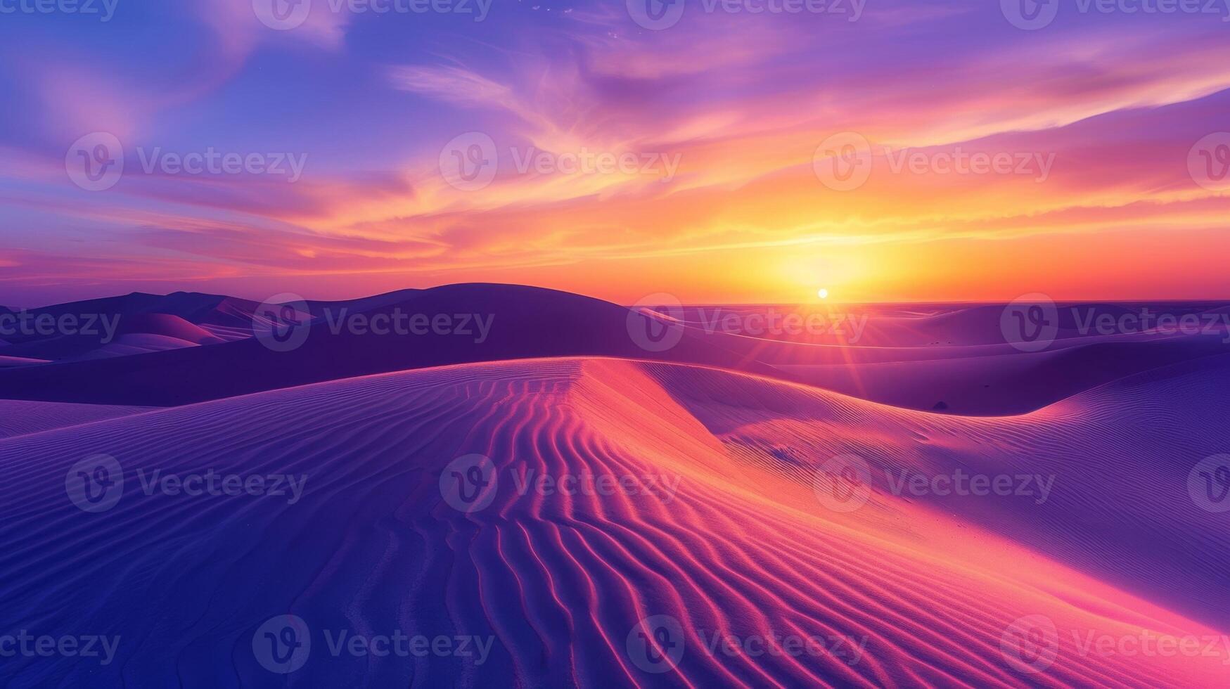 Sunrise paints unusual fractal patterns on undulating desert sand dunes with a vibrant orange and purple gradient sky as backdrop photo