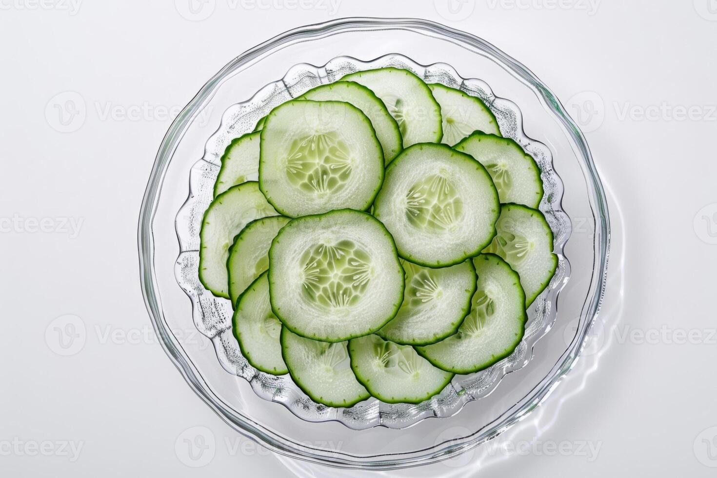 sliced cucumber on glass plate isolated on white background photo