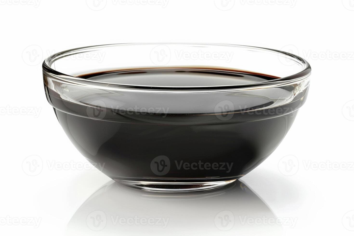 Glass bowl of balsamic reduction, glossy and dark, elegantly presented isolated on white photo