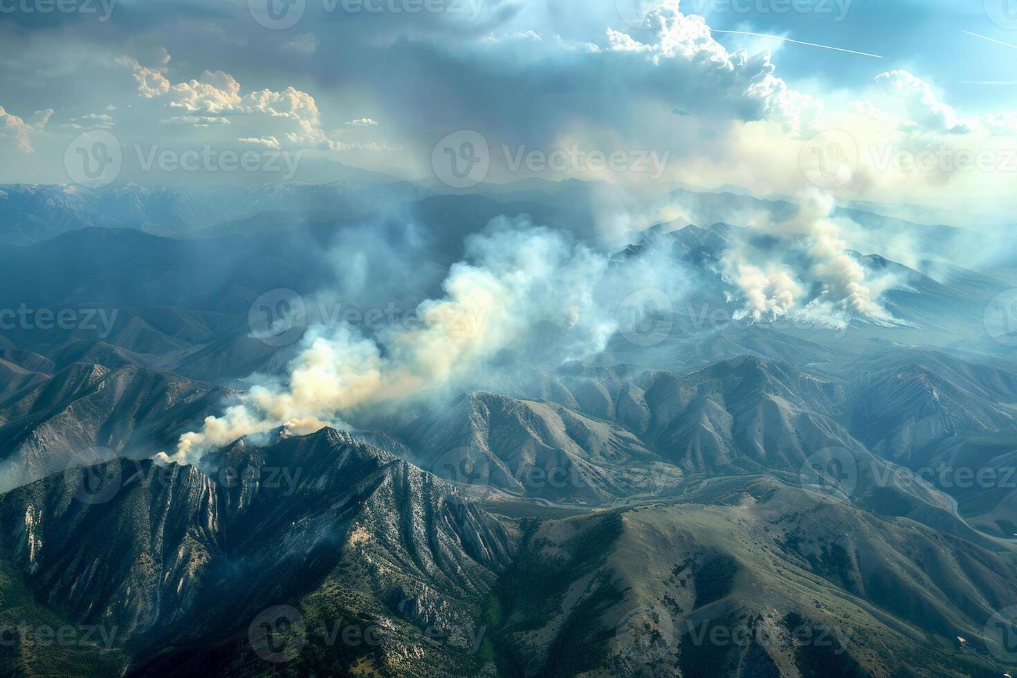 Smoke billowing up over a mountain range, visible signs of a distant wildfire impacting the landscape photo