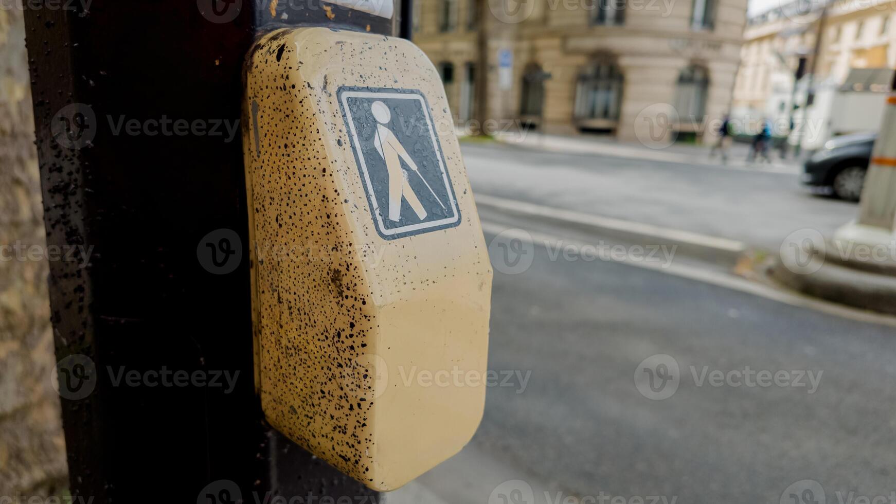 Close up of a weathered pedestrian crossing button at a street intersection, symbolizing urban infrastructure and road safety photo