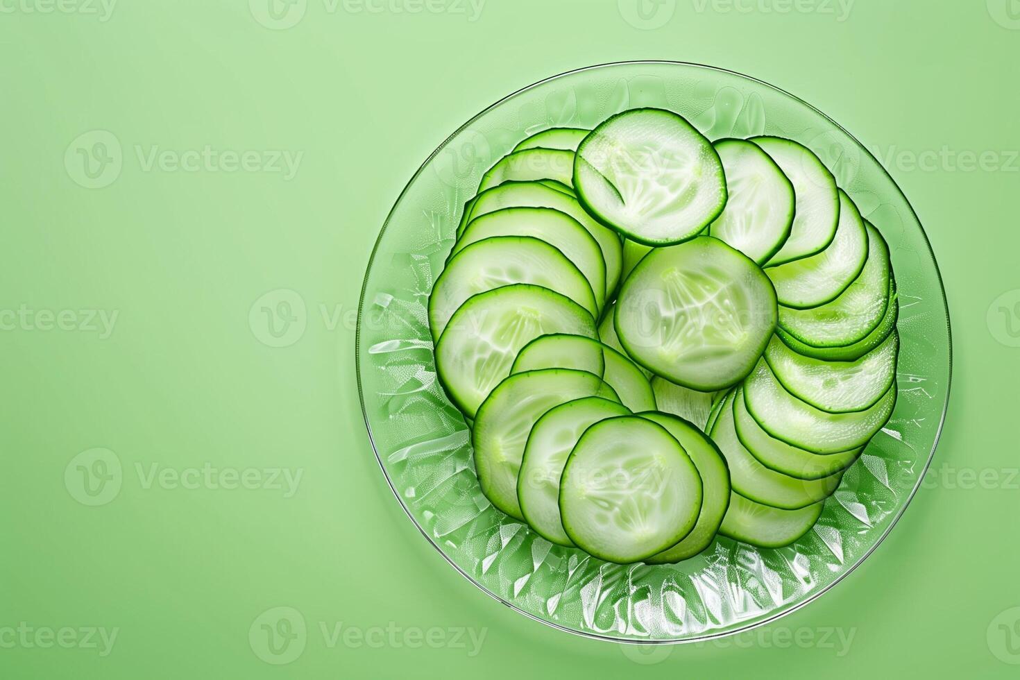 sliced cucumber on glass plate isolated on a light green gradient background photo