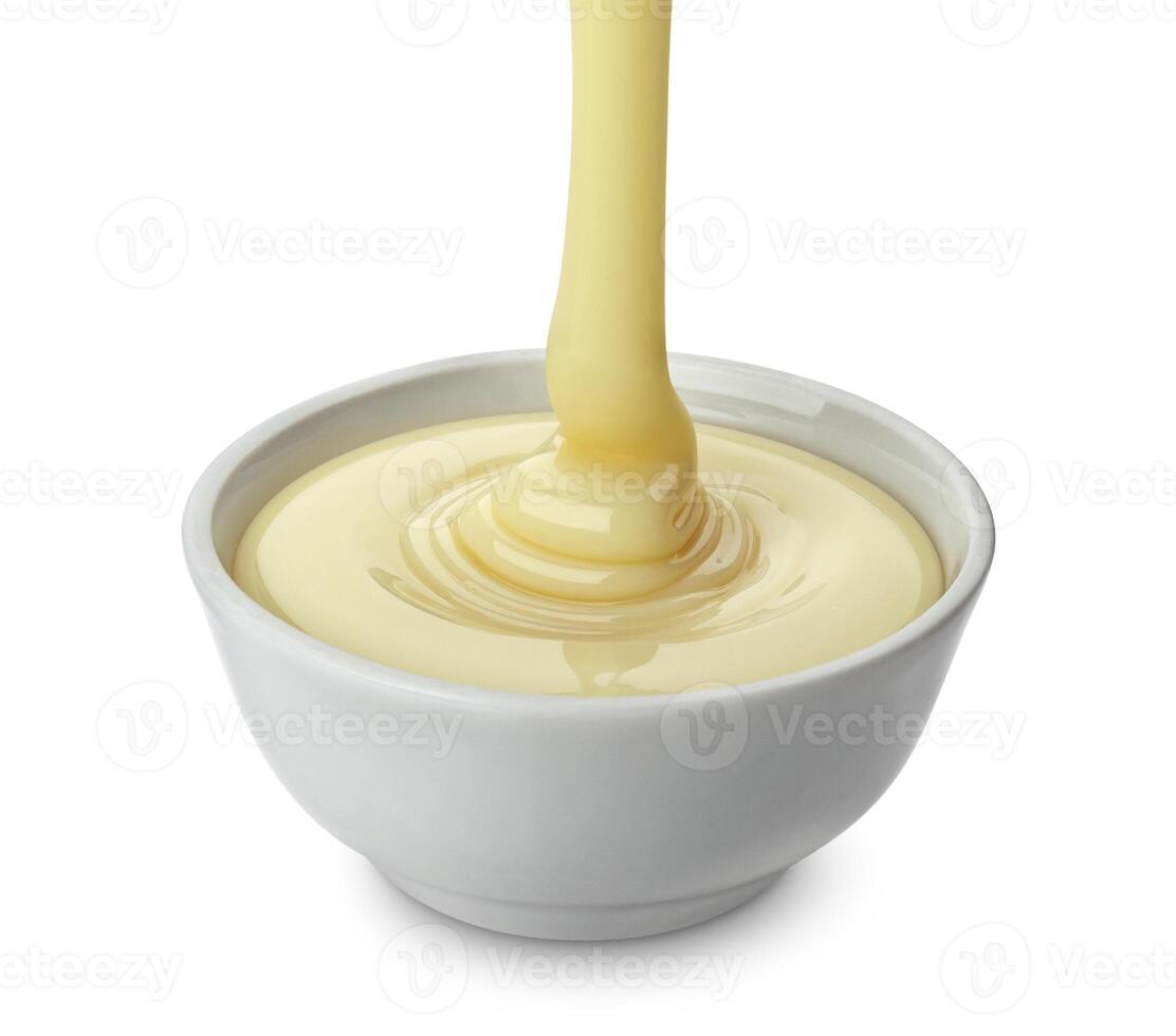 Pouring condensed milk isolated on white background photo