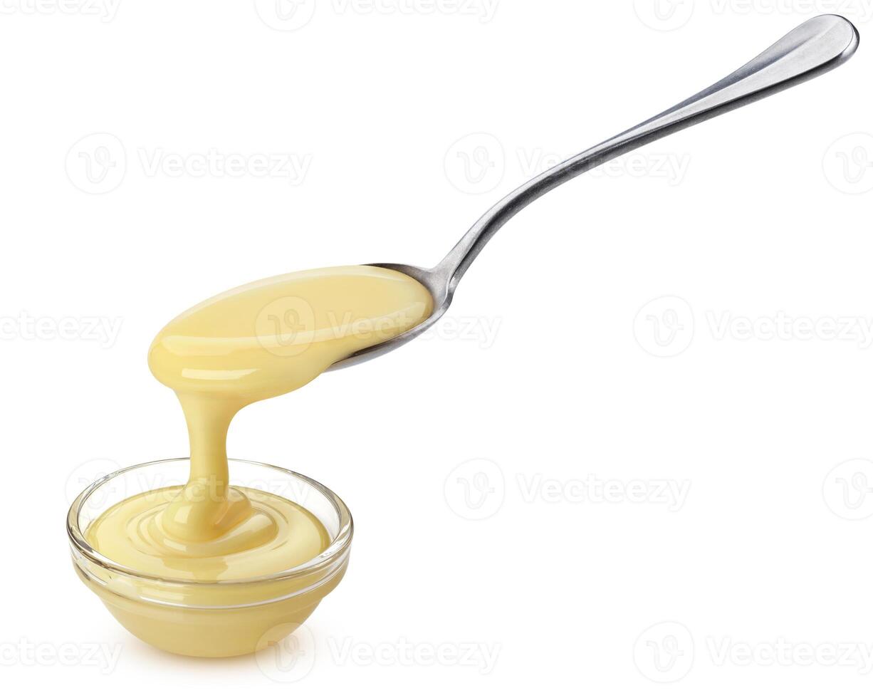 Pouring condensed milk isolated on white background photo