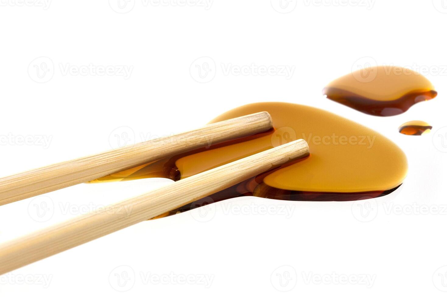 Soy sauce with chopsticks isolated on white photo