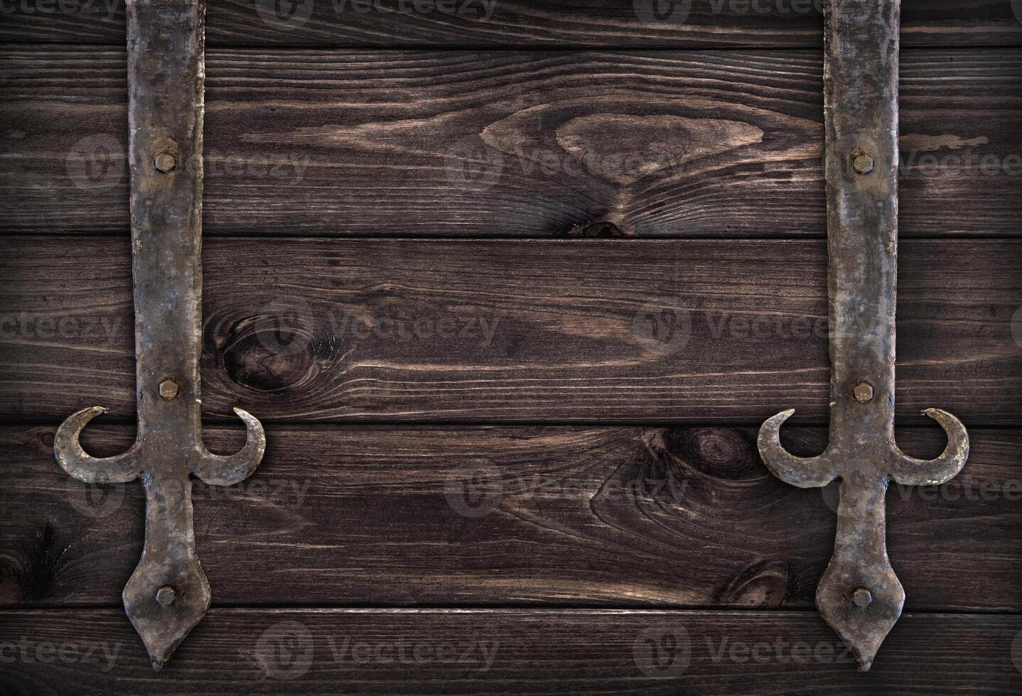 Forged metal elements on dark wooden doors photo