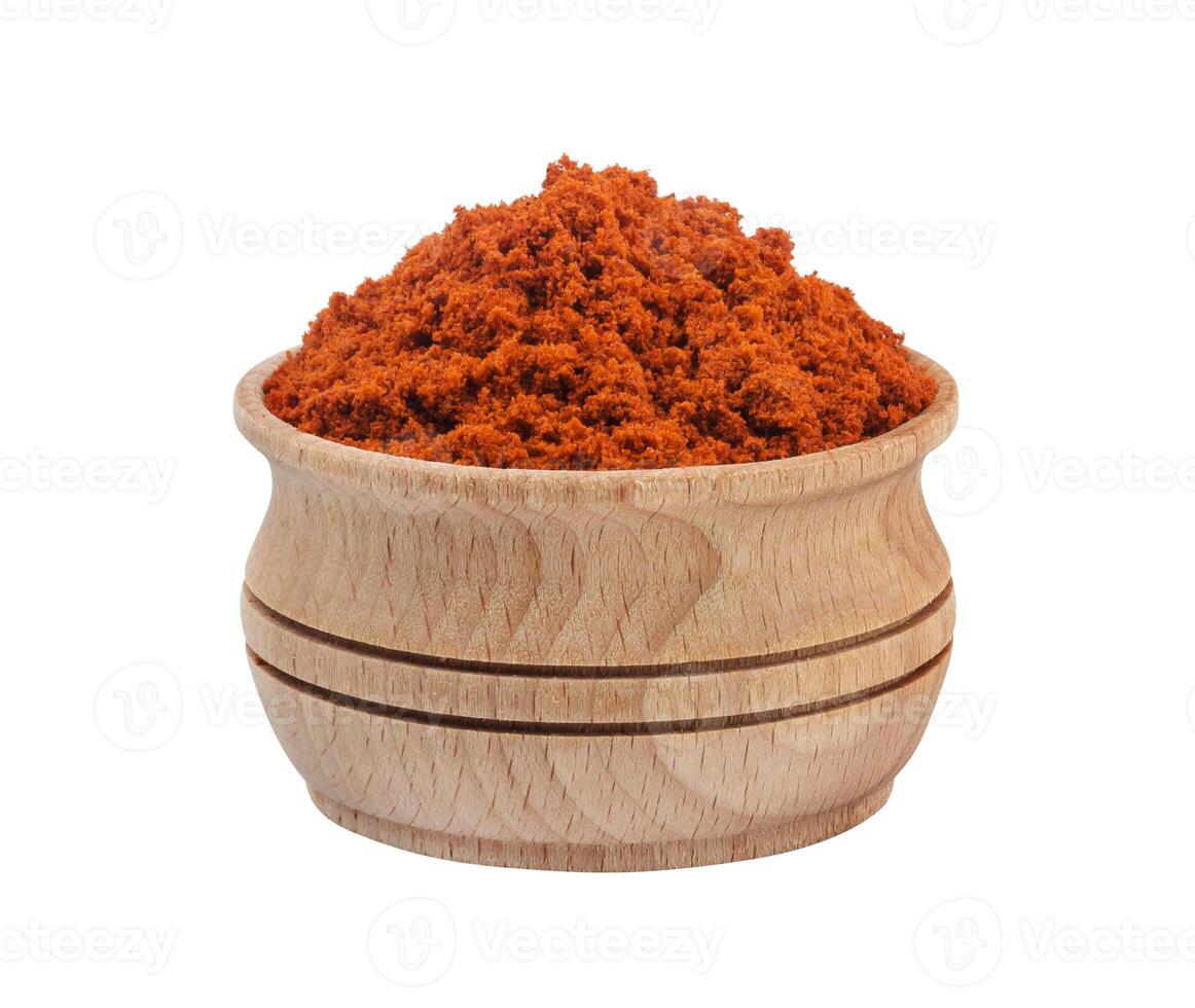 Red paprika powder in wooden bowl isolated on white background photo