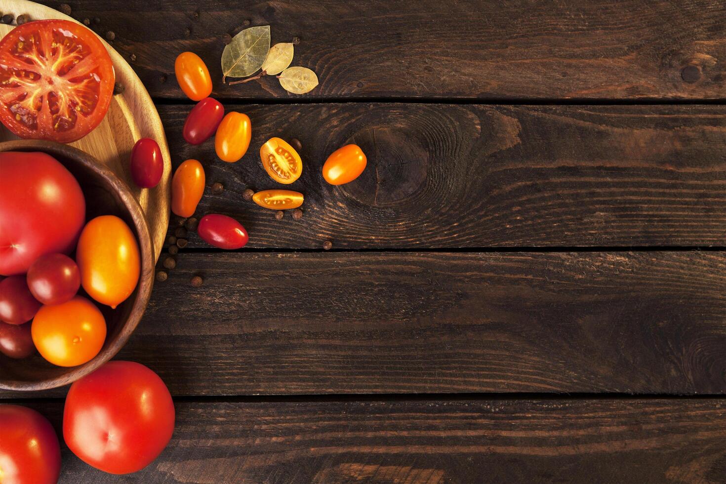 Tomatoes on wooden table background, top view photo