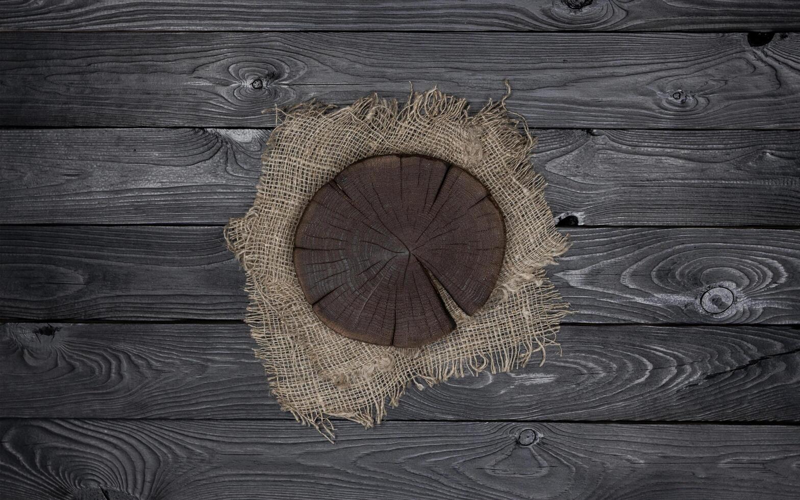 Round cutting board on black wooden table photo