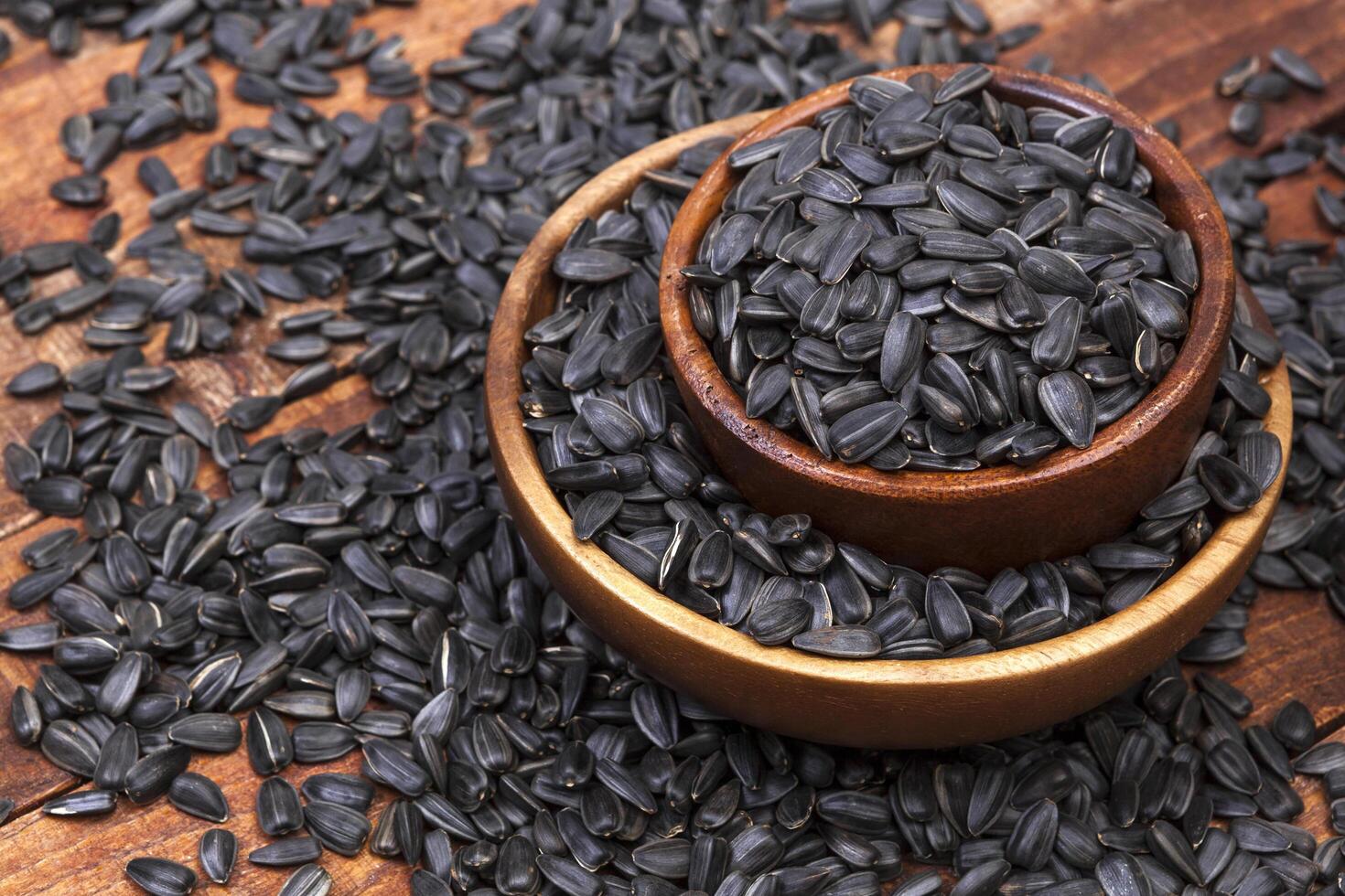 Sunflower seeds in bowl on wooden background photo