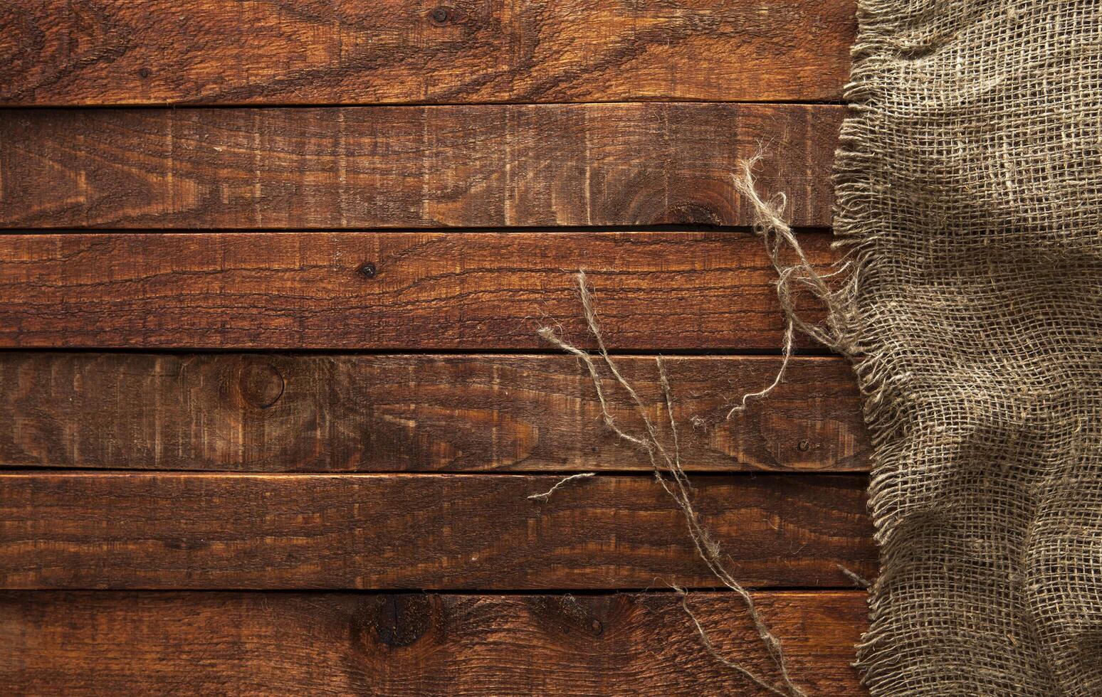 Dark wood with old burlap texture, top view photo