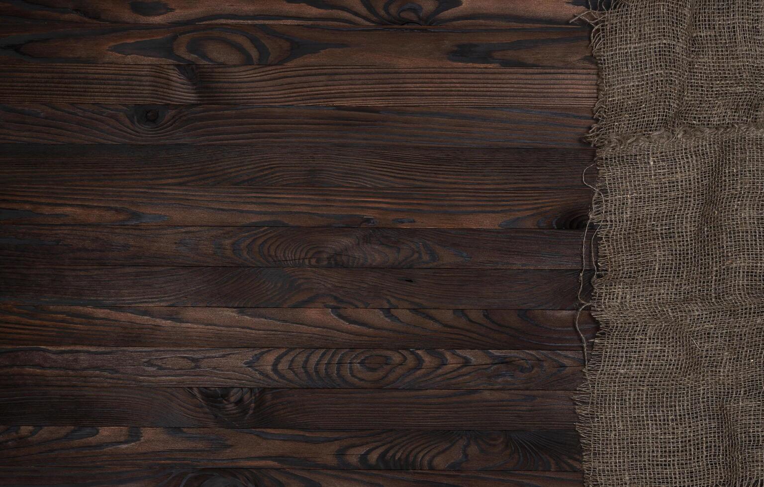 antiguo arpillera tela servilleta en marrón de madera fondo, parte superior ver foto