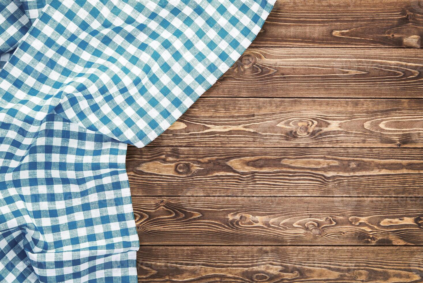 Blue checkered tablecloth on wooden table photo