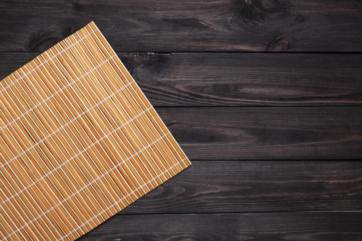 Bamboo mat on wooden table, top view photo