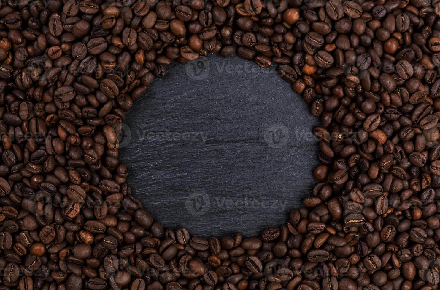 Frame made of roasted coffee beans on black table, top view photo