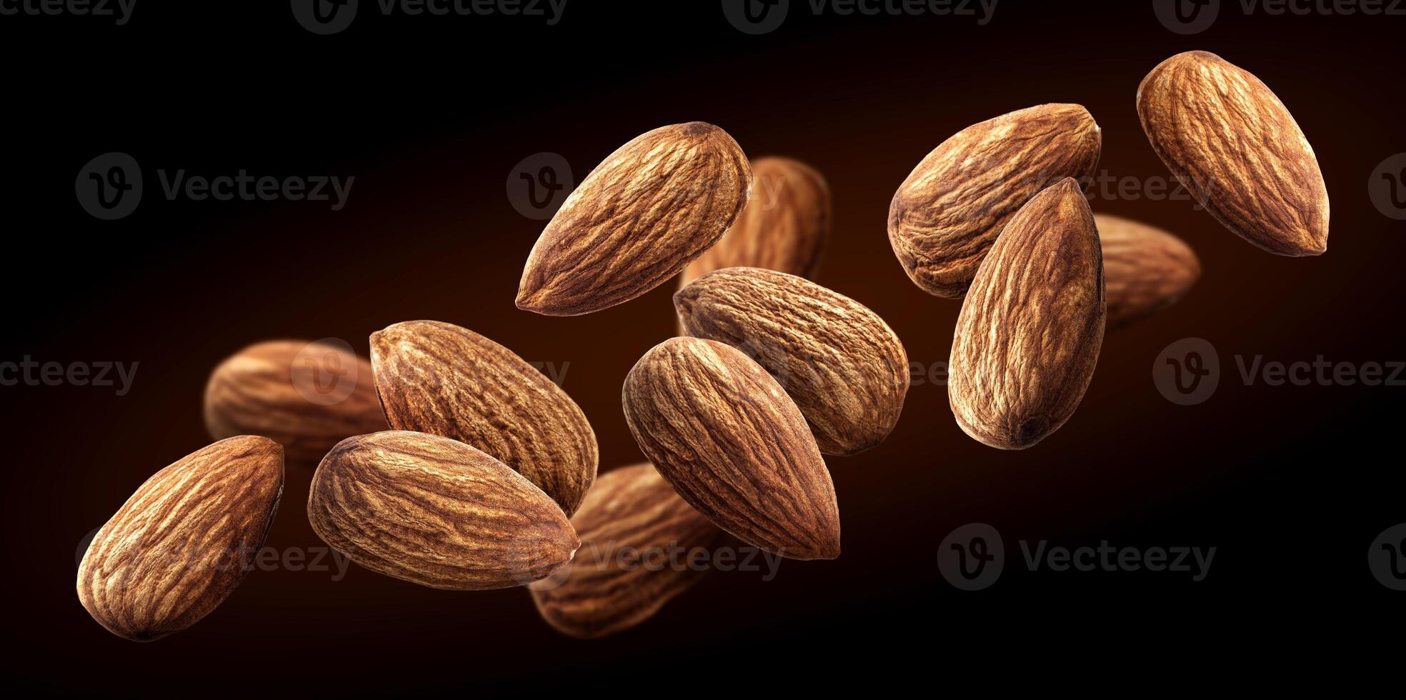 Flying almond isolated on black background photo