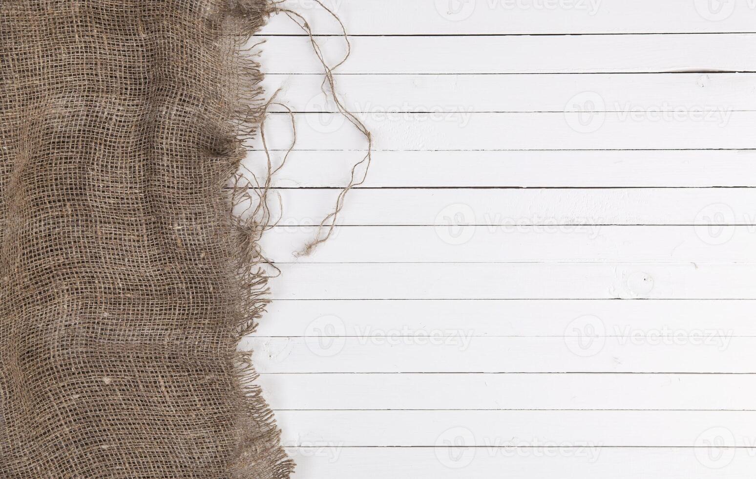 Burlap on white wooden background photo