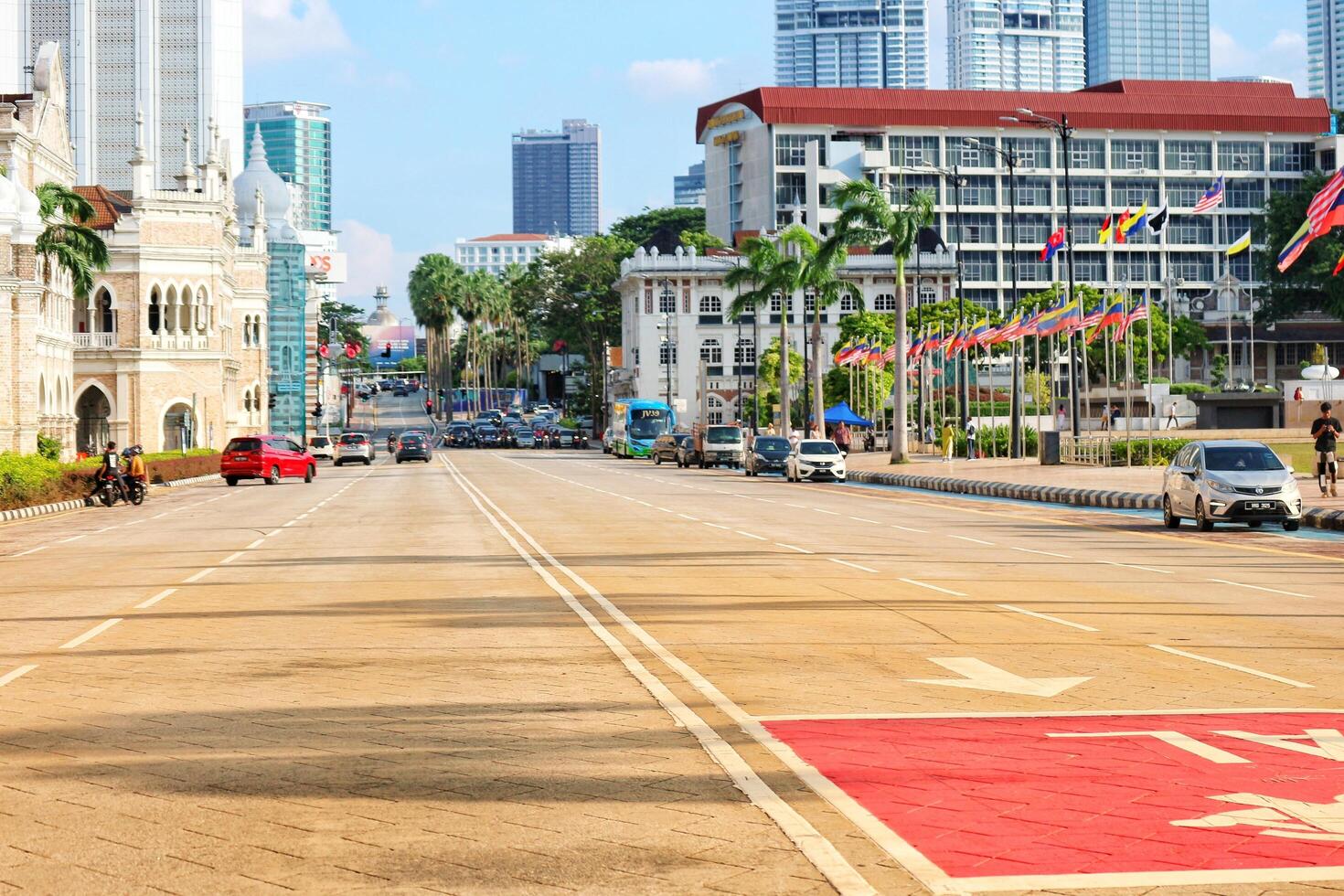 Kuala Lumpur, Malaysia on May 21, 2023. Several cars stop at a red light near the Dartaran Merdeka square and Sultan Abdul Samad Building. photo