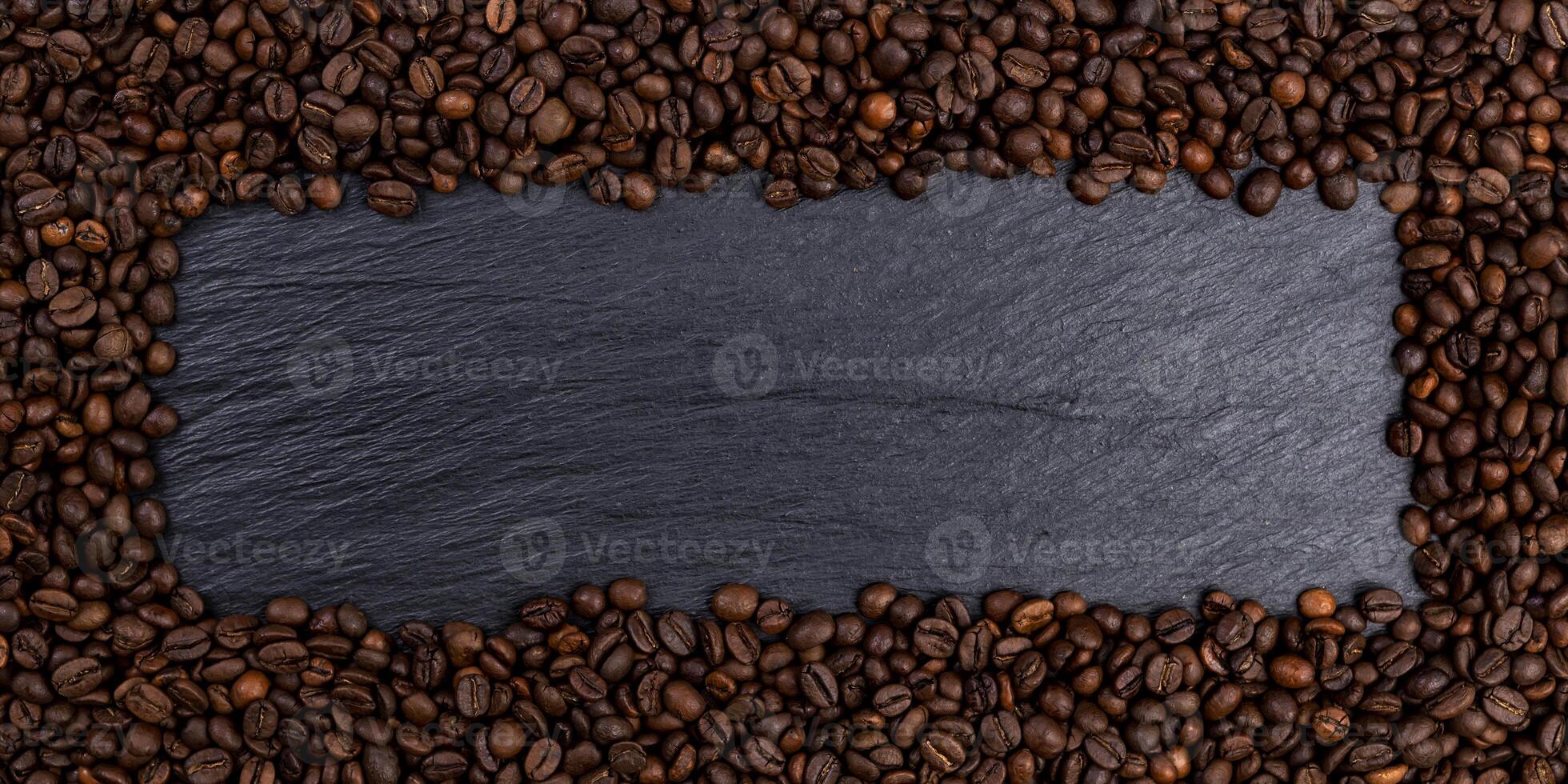 Frame made of roasted coffee beans on black table, top view photo