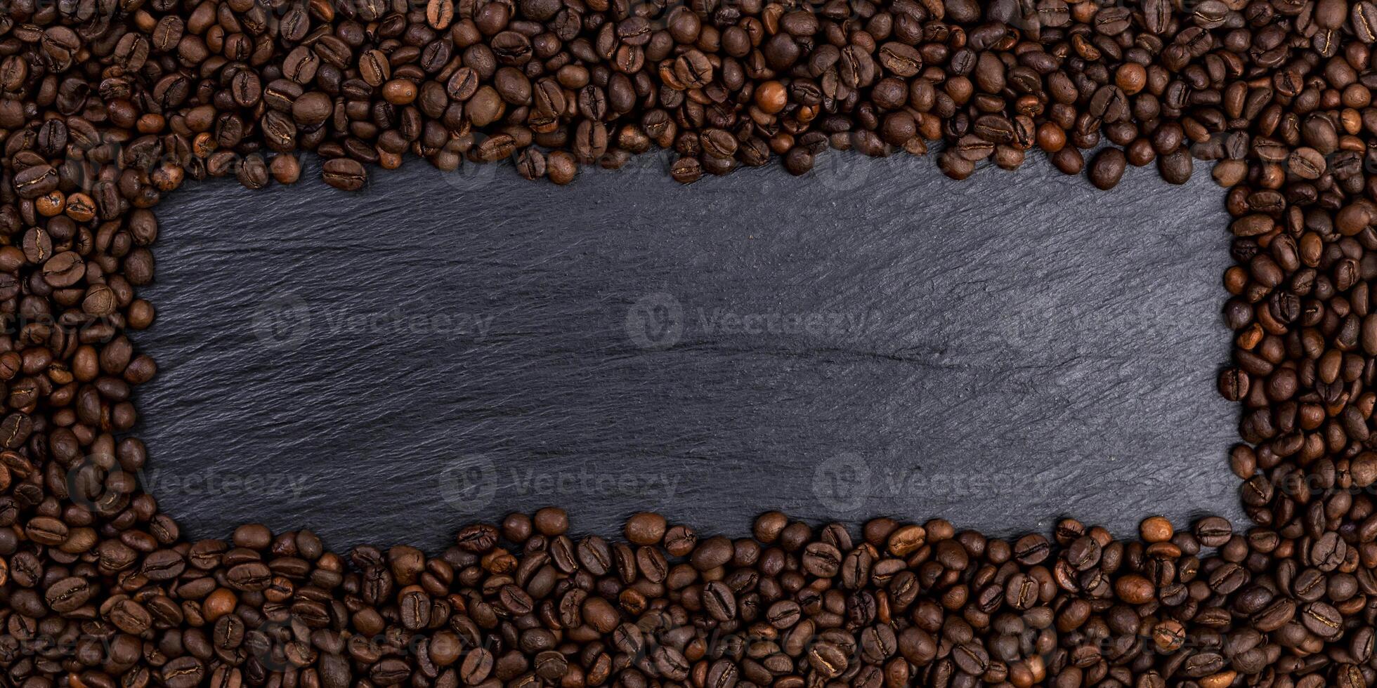 Frame made of roasted coffee beans on black table, top view photo