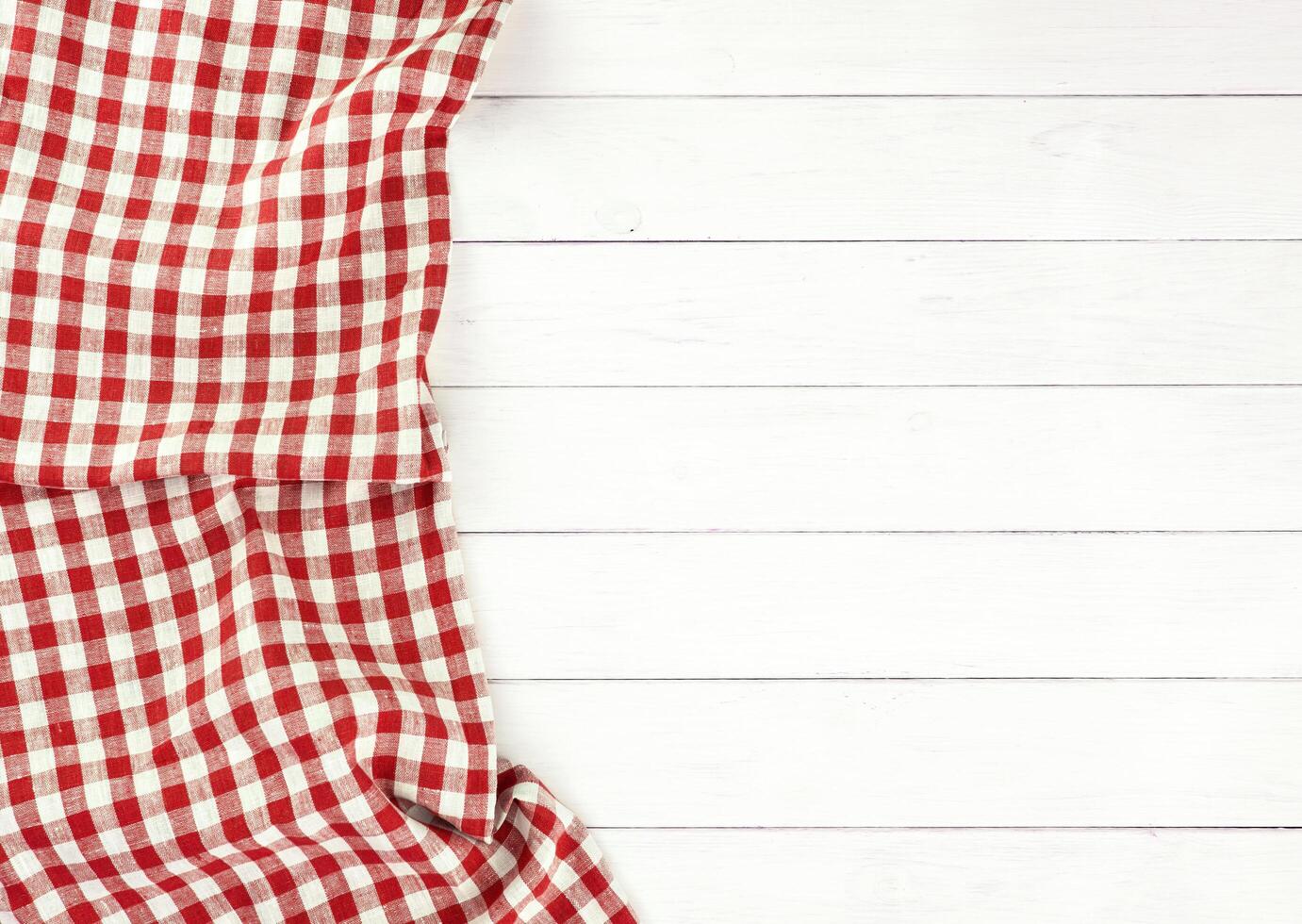 Red tablecloth on white wooden table photo