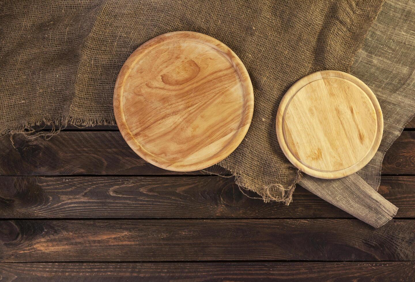 Round cutting board on dark wooden table photo
