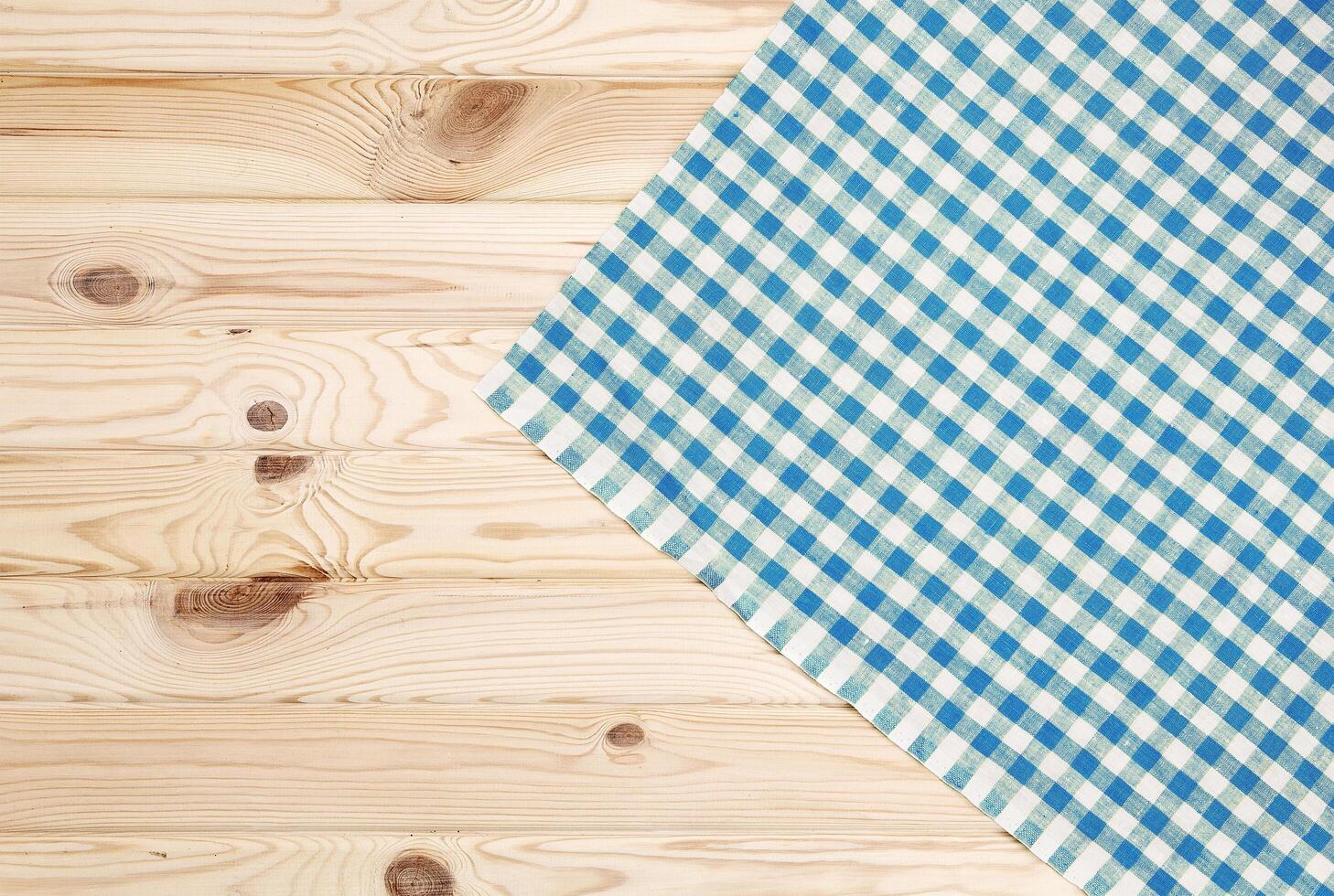 Blue checkered tablecloth on wooden table photo
