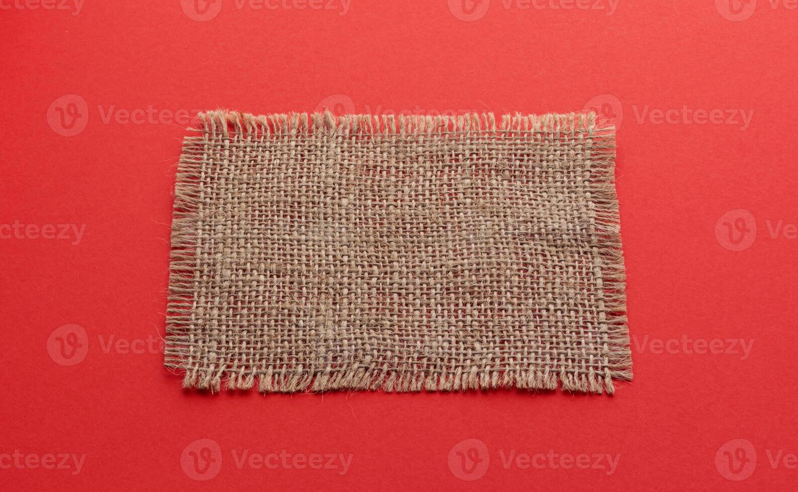 Burlap napkin on red color background photo