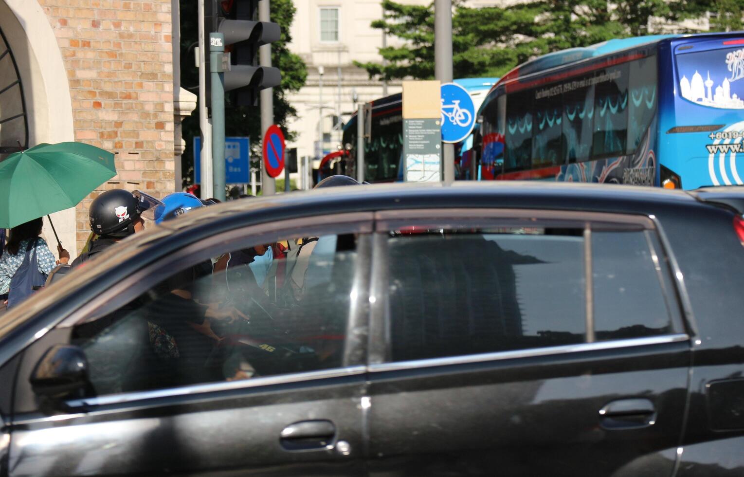 Kuala Lumpur, Malaysia on May 21, 2023. Several cars stop at a red light near the Dataran Merdeka square and Sultan Abdul Samad Building. photo