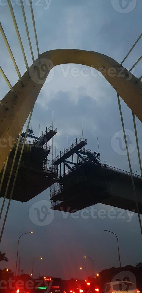 Photo of a bridge that is still under construction, where the structure of the bridge uses a balanced cantilever concrete box girder