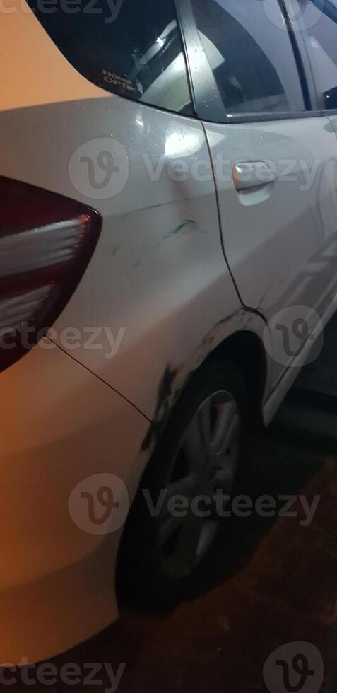 Dents and berets that occurred on a white honda jazz car due to being hit and grazed. photo