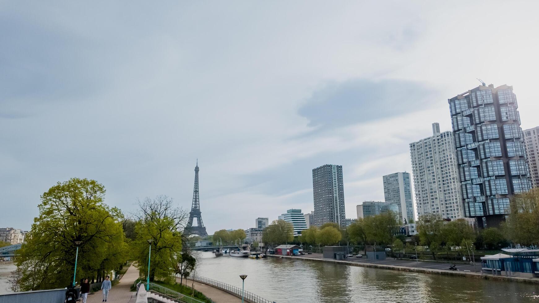 Springtime cityscape of Paris featuring the iconic Eiffel Tower along the Seine River, captured in Paris, France, on April 14th, 2024, perfect for travel and urban themes photo