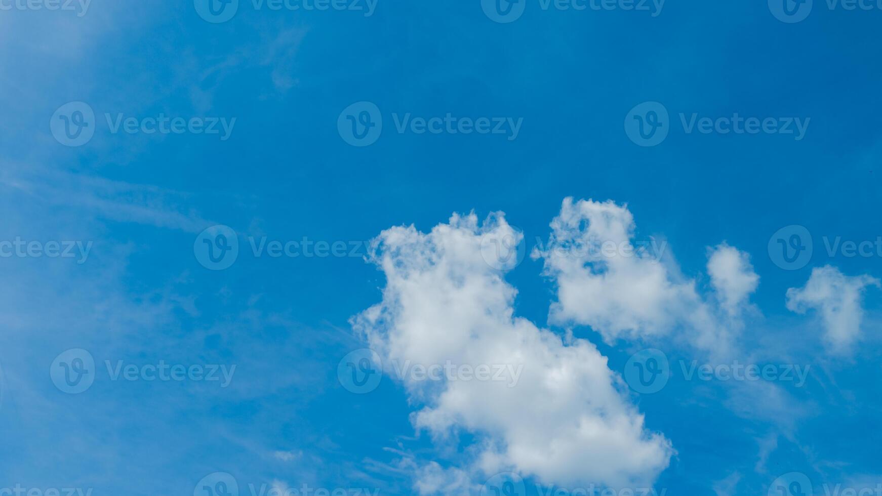 Expansive blue sky with soft white clouds, ideal for concepts of freedom, summer weather, and nature backgrounds photo